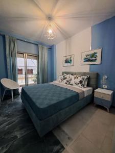 a bedroom with a large bed with blue walls at Gala Premium in Nea Potidaea
