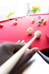 a person is playing pool on a pool table at Richjoy Lodge in Tema
