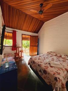 1 dormitorio con 1 cama y ventilador de techo en Quintal das Estrelas en São Pedro