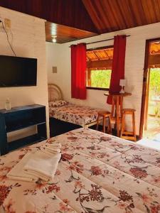 サン・ペードロにあるQuintal das Estrelasのベッドルーム1室(ベッド1台付)、テレビが備わります。