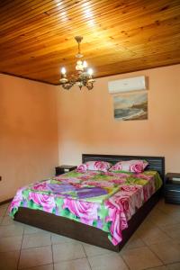 Albena Guest House في شابلا: غرفة نوم بسرير كبير بسقف خشبي