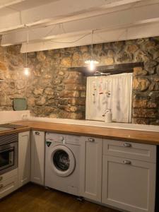 a kitchen with a sink and a washing machine at Casa Utopia 1 in Grado