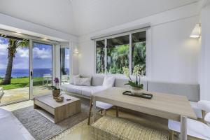 Hale Nanea home في Kilauea: غرفة معيشة مع أريكة وطاولة