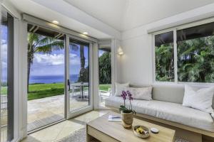 a living room with a couch and a view of the ocean at Hale Nanea home in Kilauea
