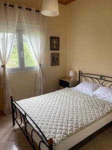 a bedroom with a bed and a window with curtains at Villa Alexandros in Ammouliani