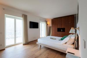 a bedroom with a bed and a large window at REVO Apartaments - Gualzi63 the Best View in Sondrio