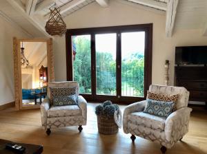伊斯普拉的住宿－Tenuta La Quassa，客厅配有两把椅子和镜子
