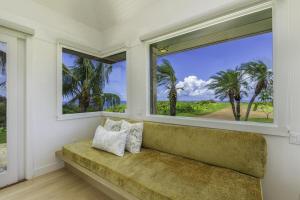 un banco en una habitación con 2 ventanas en Hale Lani home, en Kilauea
