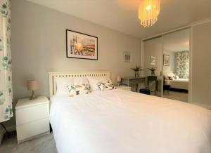a bedroom with a large white bed and a mirror at Redhill Town Centre 3 bed House near Gatwick Airport, easy commute to London in Redhill +16 photos