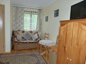 a living room with a couch and a window at U Kaczorka in Ruciane-Nida
