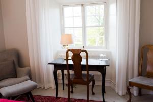 una mesa con una silla y una ventana en una habitación en Mauritzbergs Slott & Golf, en Mauritsberg