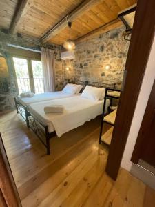 a bedroom with a bed and a stone wall at Casa Marel in Vlikhádha