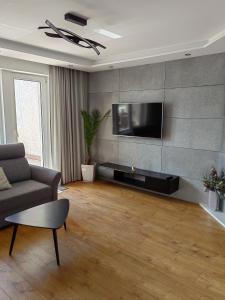 a living room with a couch and a flat screen tv at Apartament nad jeziorem Sport i Rekreacja in Ełk