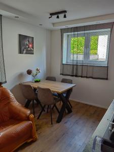 a dining room with a wooden table and chairs at Apartament nad jeziorem Sport i Rekreacja in Ełk