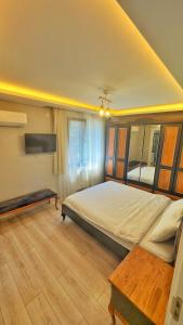 a bedroom with a large bed and a wooden floor at Osmanlı Suite Airport in Trabzon