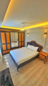 a bedroom with a large bed and a table at Osmanlı Suite Airport in Trabzon