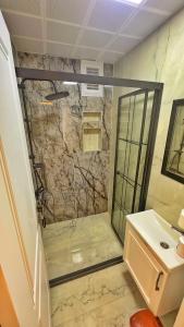 uma casa de banho com um chuveiro e um lavatório. em Osmanlı Suite Airport em Trabzon