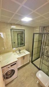 a bathroom with a sink and a washing machine at Osmanlı Suite Airport in Trabzon