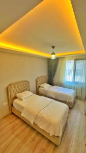 a bedroom with two beds and a yellow ceiling at Osmanlı Suite Airport in Trabzon