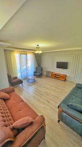 a living room with a couch and a flat screen tv at Osmanlı Suite Airport TRABZON in Trabzon