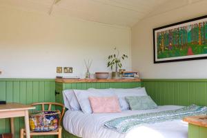 a bed in a room with green walls at The Hut at Pengelli in Nelson