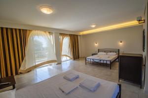 a room with two beds and a balcony at Ocean Hotel Resort in Kastrosikia