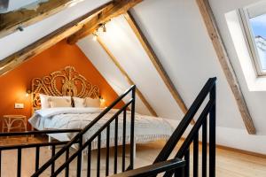 een slaapkamer op zolder met een oranje muur en een bed bij Roua Ludica Apartments in Braşov