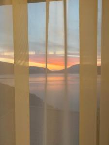 a view of a sunset from a window at Agape Rose Hotel in Tivat