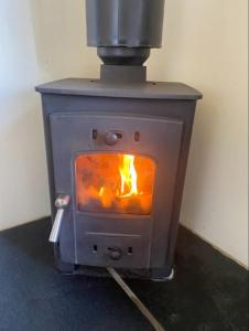 a stove with a fire inside of it at Plum Hut in Torquay