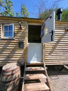 a wooden cabin with stairs leading to a door at Plum Hut in Torquay
