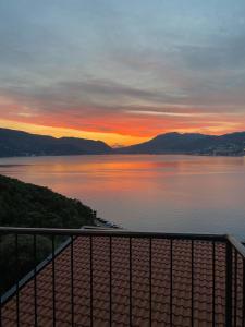 a view of a lake at sunset from a balcony at Agape Rose Hotel in Tivat