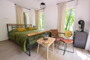 Living Forest Resort في مورفسكه تيبليتسه: غرفة نوم بسرير وكرسي وطاولة