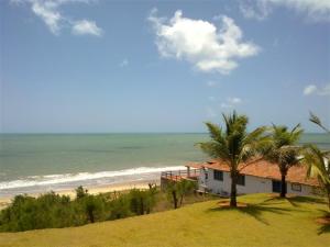 a house on the beach next to the ocean at Casa espetacular em condomínio pé-na-areia, PZ11 in Rio do Fogo +25 photos