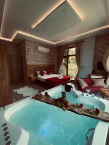 a large bath tub in a room with a bedroom at Vadidekal Suite Hotel in Çamlıhemşin