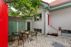 Roua Ludica Apartments في براشوف: فناء به طاولة وكراسي أمام المنزل