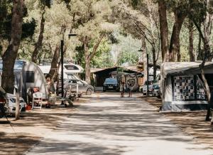a street with a bunch of parked cars and trees at Tamarit Beach Resort in Tamarit