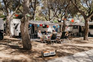 a group of people sitting at a table in front of a trailer at Tamarit Beach Resort in Tamarit
