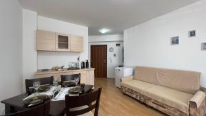 a living room with a couch and a table and a kitchen at Bratanov Royal Palm Apartments in Sveti Vlas