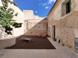 two chairs sitting in a courtyard of a building at La Santa in Almagro