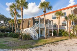 ein großes Haus mit Palmen davor in der Unterkunft The Seaclusion Too - 300 Seventh Street in Saint Simons