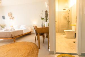 una camera con letto, scrivania e doccia di Dohos Skiathos Suites a Città di Skiathos