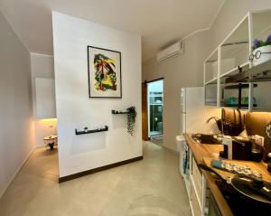 a kitchen with a white wall with a picture on it at “Bedda Mattri” dimora siciliana in Avola