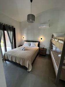 1 dormitorio con 1 cama y 2 literas en Naiades Villas Aigli, en Ladharió