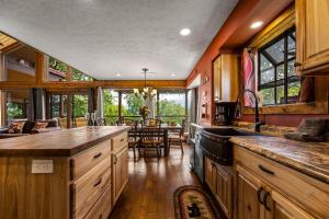 a kitchen with wooden cabinets and a dining room at Twinflower Summit - Incredible views, pet friendly! in Gatlinburg +29 photos