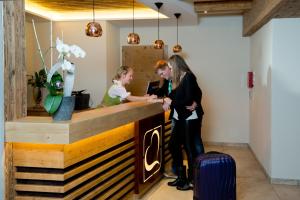 two women standing at a counter in a room at Hotel Taxerhof in Radstadt