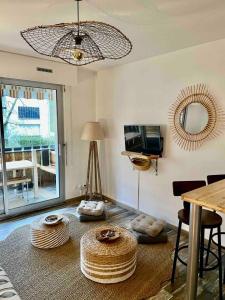 een woonkamer met een tafel en een spiegel bij Studio Cosy Tout Confort - 180m Plage - Parking in Saint-Georges-de-Didonne