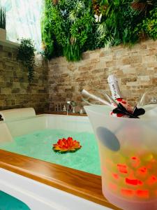 a bath tub filled with water with a flower in it at Suite i biddizzi da Sicilia in Catania +69 photos