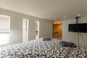 Schlafzimmer mit einem Bett und einem Flachbild-TV in der Unterkunft Kazinczy 10 Apartment with 3 bedrooms in Budapest