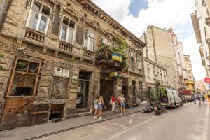 eine Gruppe von Menschen, die eine Straße entlang gehen, neben einem Gebäude in der Unterkunft Kazinczy 10 Apartment with 3 bedrooms in Budapest