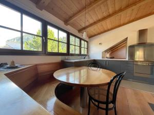 a kitchen with a wooden table and some windows at Apartment Cesa Collina Superior in Ortisei